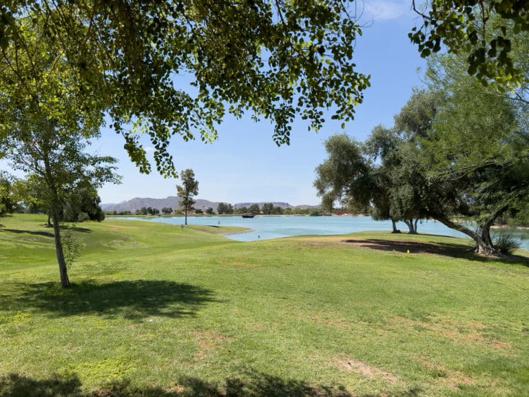 Picture of a park with trees and a small lake.